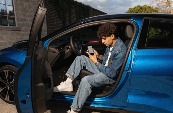 EV driver using phone app to check battery level and plan charging routine