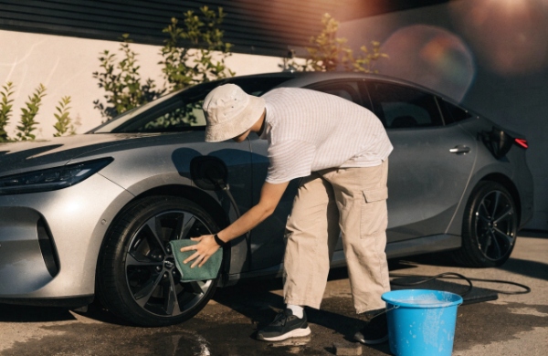 Person safely washing an EV after unplugging the charger