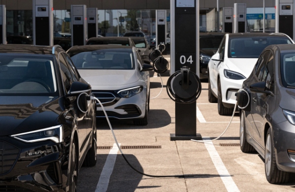 Organized high-traffic EV charging station featuring a retractable cable management system
